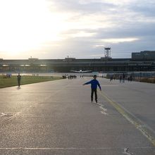 滑走路と夕日とローラースケートをする少年
