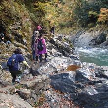 渓谷沿いの滑りやすい岩の上を歩く