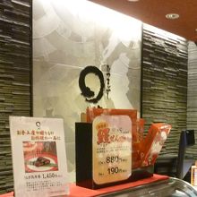 バックにまるやのロゴ