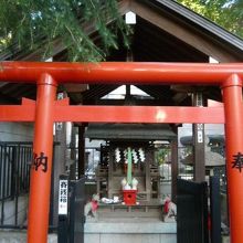 赤色の鳥居の奥に鎮座している甲賀稲荷神社の祠です。欅造りです