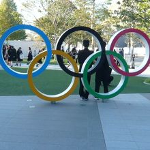 オリンピックのマークの前で記念撮影する修学旅行の関係者です。