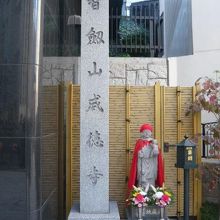 コンクリートの建物の１階入口の横に、威徳寺の標石柱があります