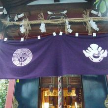 三河稲荷神社の社殿の正面です。幕の向こうにガラス戸が見えます