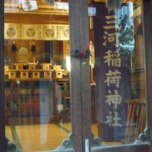 三河稲荷神社の奥のガラス戸の中には、大きな幟が見えます。