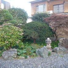 石が敷き詰められ、手入れの行き届いた庭木が植えられています。