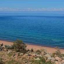 イシク・クル湖南岸と、遠い北岸に連なるクンゴイ・アラ・トー。