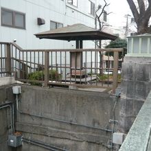 万年橋の北側の親柱の西側です。広場の南端に碑があります。