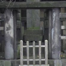 石畳の路の先に鳥居があり、石段の奥に大きな墓石があります。