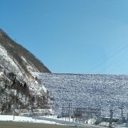 石を積み上げたダムが雪景色　