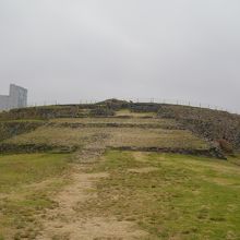 ピラミッドの後ろに近代的なビルが見えます。