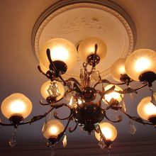 漆喰の天井にシャンデリアの贅