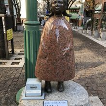 赤御影石の像。足元に募金箱