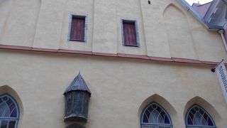 淡いイエローの三角屋根の建物です