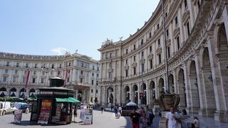 中央に噴水があり、半円形の建物があります。