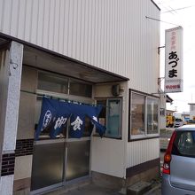 道路を挟んだ向かい側に広い駐車場がある