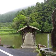 神社に参拝するには池にかかる屋根付きの木製の太鼓橋を渡ります