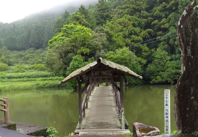 神社に参拝するには池にかかる屋根付きの木製の太鼓橋を渡ります