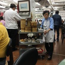 おばさんがワゴンで点心を運んできます