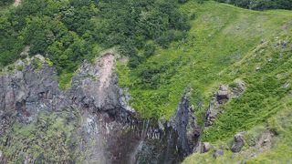 地層の間から滝になっている