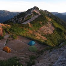 奥のテント場とトイレ（左の建物）