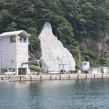 明治・昭和・平成の大津波水位標記がある製氷施設建物と崖。
