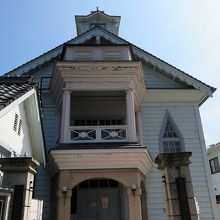 下見張りの壁はペンキ塗りという素朴さに、モダンな三角窓