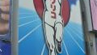 周辺に多くの看板が取り付けられたのて゜目だ立ちにくくなったグリコのネオン