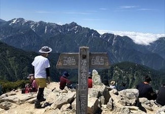 長野県と富山県の県境にありました。山頂近くの山荘で売っている水は富山県産でした。山頂は広く、一近いの五竜岳を一望できました。登山の途中に鎖もあり、階段もあり、雪渓もあり、とても登り甲斐がありました。さらに途中の八方池の景色が最高でお勧めです。