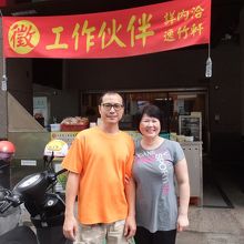 お店の前でご夫婦、お店の建物