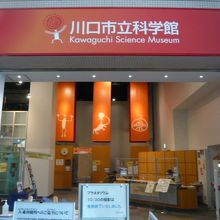 川口市立科学館の入口です。赤い標識が鮮やかに映えます。