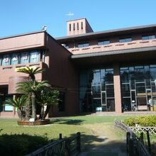 太陽の陽を一杯に浴びている別所沼会館のテラスと池と前庭です。