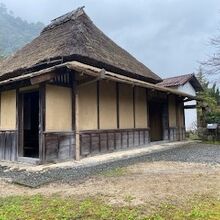 茅葺屋根の旧家と、奥には土蔵