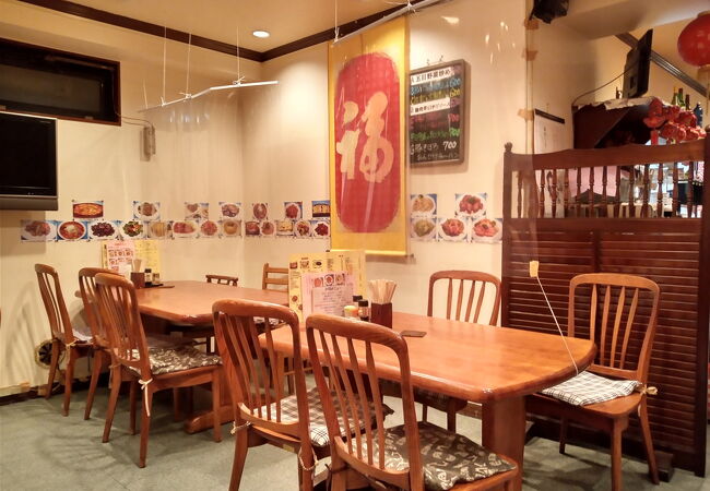 4人掛けのテーブルの真ん中にビニールシートがあり、向かい合う客はシート越しに話す中華店。
