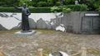 説明の碑文や背後の世界地図も