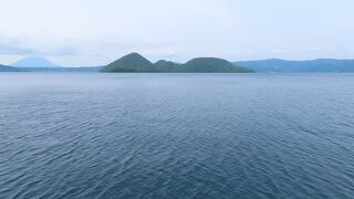 湖に真ん中に中島が浮かび、バックには羊蹄山も
