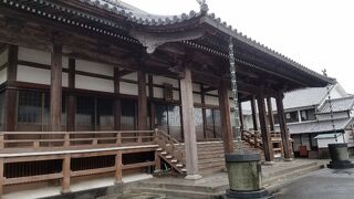 白い壁に続いて重厚な山門が現れる