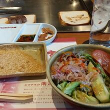 サラダと奥のトーストの上にステーキ