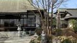 竹箒を持った小僧の石像がある