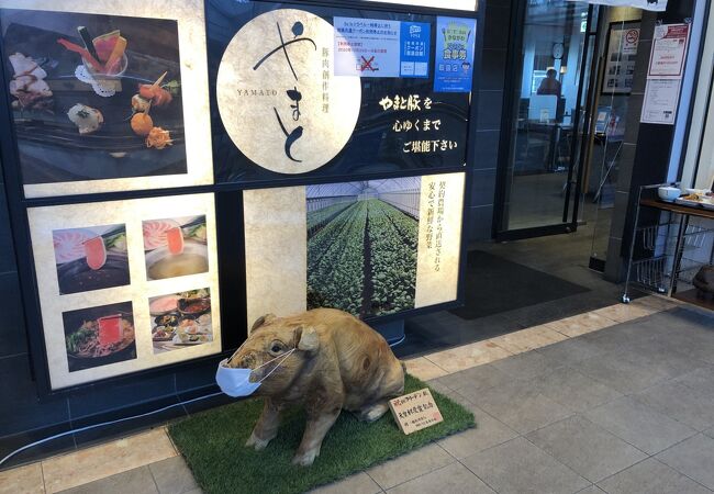 店頭に木彫りの豚がいる