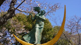 若い母親に抱かれた子どもが平和のラッパを吹いています