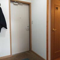 踏入の右側に洗面台・トイレ、左側に冷蔵庫、ハンガーがあります