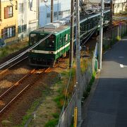 下町の垣根越しをゴトゴト走りぬけるローカル線