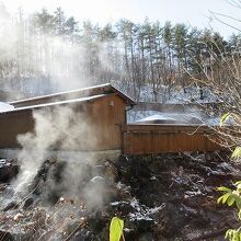 低い建物と塀で囲まれた大露天風呂です。