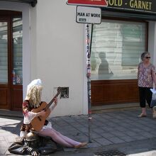 チュミル像に座りギター演奏するコスプレイヤー