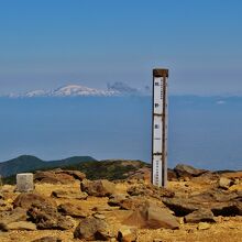 「熊野岳」の表札を別の角度より。背後には月山の山並み