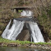 恵庭渓谷の大木の間から雄々しい姿で流れ落ちる滝