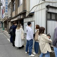 狭い道路の端に並んで待ちます