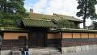 オレンジ色の塀に囲まれたお屋敷は何?