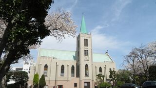 青空に塔屋根部が映える教会