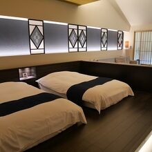 広い畳敷きの和室にツインベッドがあります